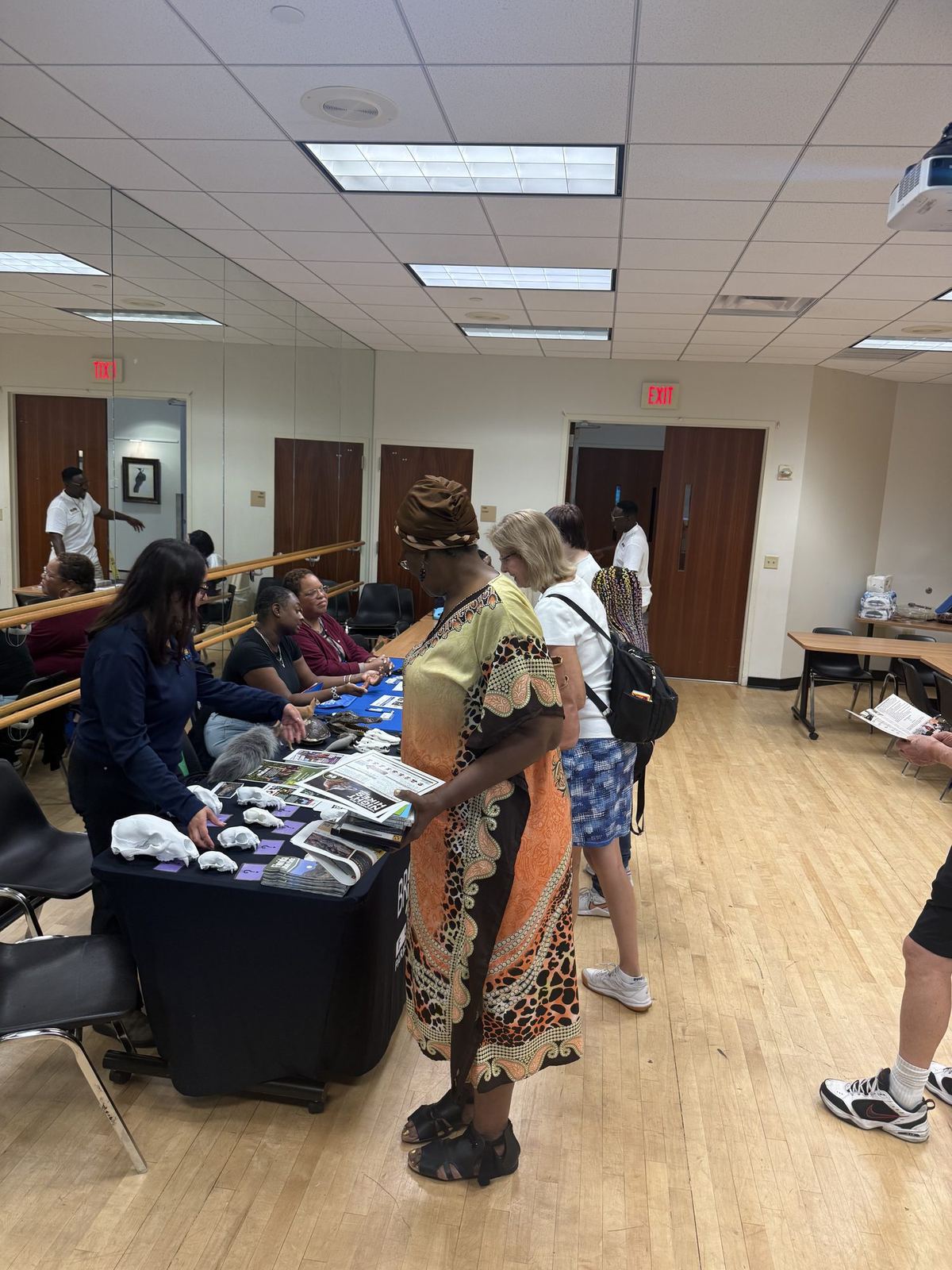 Community members browsing materials at the ACES resource table during a community fair