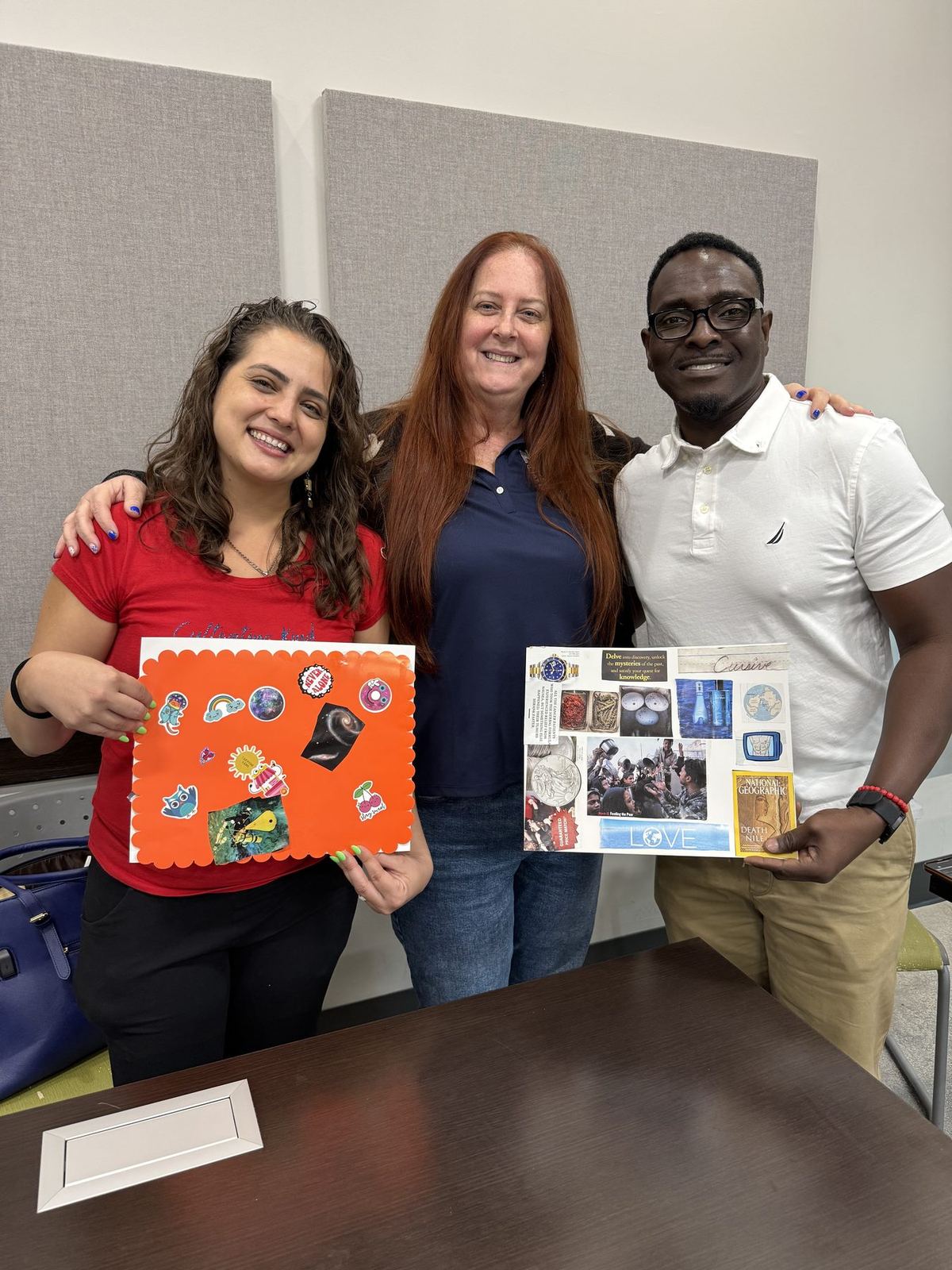 Two ACES staff members and a participant smiling together while holding the vision boards they made